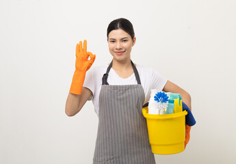 Young housekeeper woman holding bucket of cleaning products ready for cleaning home on isolated white background.