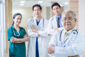 Fototapeta premium Portrait Group of Asian doctor and nurse crossing arm with smiling. Professional medical team standing in hospital office ward and giving encouragement to patient people after work in recovery room.