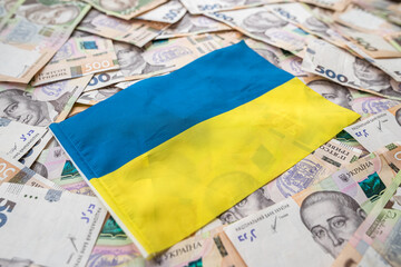 Ukrainian hryvnia lying on national blue yellow flag of Ukraine