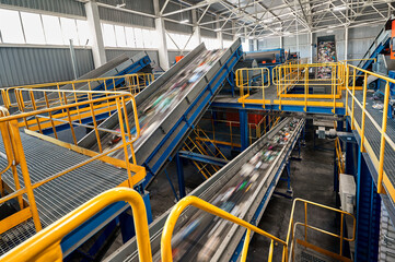 Conveyors carry trash and empty platforms at recycling plant