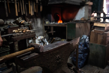 Close up view of heated metal and anvil. Blacksmith in the production process of other metal...