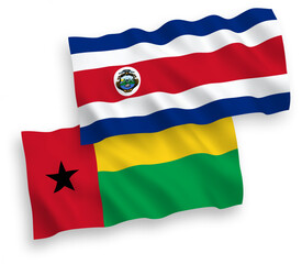 National vector fabric wave flags of Republic of Costa Rica and Republic of Guinea Bissau isolated on white background. 1 to 2 proportion.