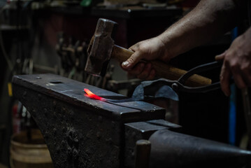 Close up view of heated metal and anvil. Blacksmith in the production process of other metal...