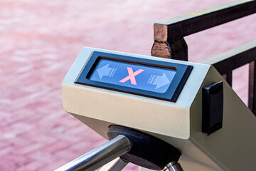 Modern automated metallic turnstile entrance system with stop sign on it means closed pass....