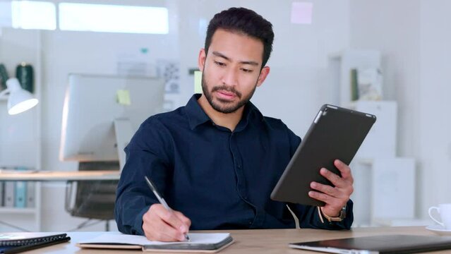 Web developer reading digital tablet, writing notes and thinking of design for user friendly marketing webpage or website for clients. Young creative planning or innovating ideas for company homepage