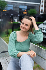 A woman is sitting on a bench looking at the camera