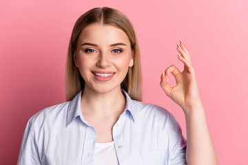 Photo of young cheerful girl show fingers okey symbol recommend promotion isolated over pink color background