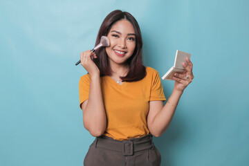 Portrait of a young beautiful Asian woman doing her makeup