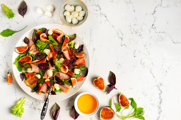 Freshly made Chopped Salad in Italian restaurant, mozzarella, figs, prosciutto or jamon. Copy space