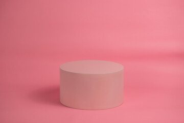 Empty podium for display cosmetic product. Platform arrangement in pink pastel color in trendy minimalist style. Composition of cylinders and cubes layout for feminine background