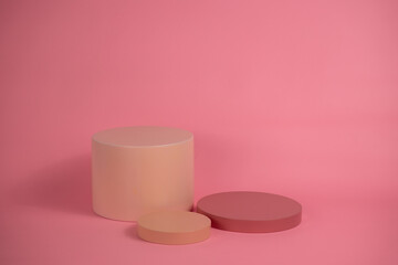 Empty podium for display cosmetic product. Platform arrangement in pink pastel color in trendy minimalist style. Composition of cylinders and cubes layout for feminine background