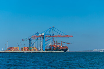 Naklejka premium Loading cargo in the seaport. Marine industrial trade port. Black Sea. Export and import by sea. City of Odessa, Ukraine