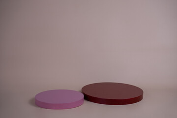 Empty podium for display cosmetic product. Platform arrangement in pink pastel color in trendy minimalist style. Composition of cylinders and cubes layout for feminine background