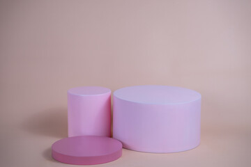 Empty podium for display cosmetic product. Platform arrangement in pink pastel color in trendy minimalist style. Composition of cylinders and cubes layout for feminine background