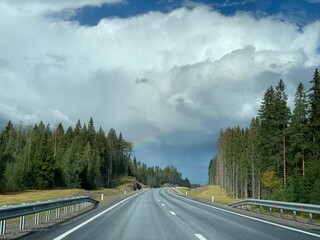 Road among the hills and woodlands under an overcast sky