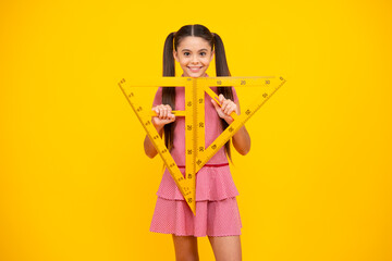School girl holding measure for geometry lesson, isolated on yellow background. Measuring equipment. Student study math. Happy teenager, positive and smiling emotions of teen schoolgirl.