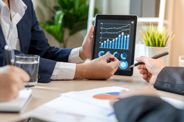 Businessman pointing stock charts and showing stock sign analyzing graph indicators. Businessman brainstorming at meeting time. Interest rates, income, investments, mortgages