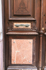 Old wooden and marble door with beautiful iron door handles