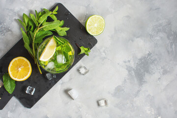 Refreshing summer alcoholic cocktail mojito with ice, fresh mint and lime. Top view