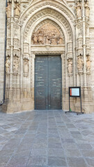 Seville, Spain, September 11, 2021: Detail of Main door of the Assumption of Saint Mary of the See Cathedral, in the center of the west facade, is well-preserved and elaborately decorated.