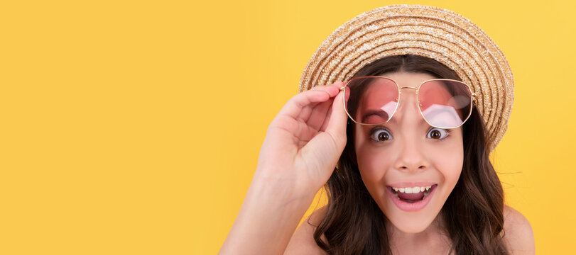 surprised child in summer straw hat and glasses has curly hair on yellow background, beach fashion. Child face, horizontal poster, teenager girl isolated portrait, banner with copy space.