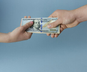 A man's and a woman's hand passing bills close-up. The concept is a transaction, a purchase.