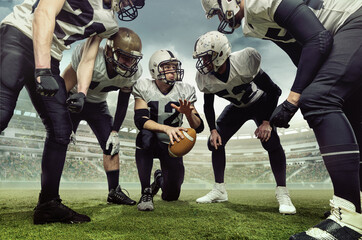 Teammates. Team of male american football players before sport match at stadium over cloudy sky...