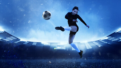 Energetic female soccer or football player in sportwear kicking ball in jump at evening stadium background. Concept of sport, motion, movement.