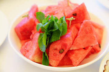 pieces of watermelon and mint on a plate. 