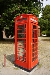 Fototapeta na wymiar Red telephone box, a telephone kiosk for a public telephone. Salzwedel, Saxony-Anhalt, Germany.