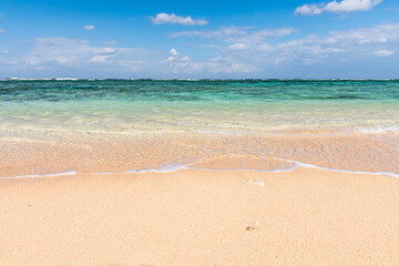 Fototapeta na wymiar Gentle turquoise sea wave on clean sand beach
