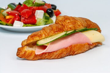 Croissant with ham and cheese with Greek salad, isolate on a white background