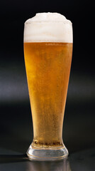 A misted glass of light beer and isolated on a dark background