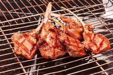 Grilled lamb square on the background of a grill grate