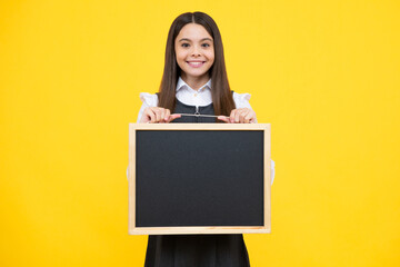 Teenage girl child hold chalkboard. Elementary school girl holding a blank blackboard chalk board. Copy space, mockup banner. Happy girl face, positive and smiling emotions.