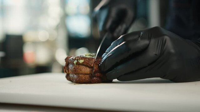 The chef cuts the filet mignon into pieces before serving the dish