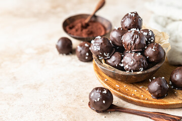 Vegan chickpea and peanut butter candies in chocolate glaze sprinkled with coconut chips. Energy balls. Healthy raw dessert without sugar.
