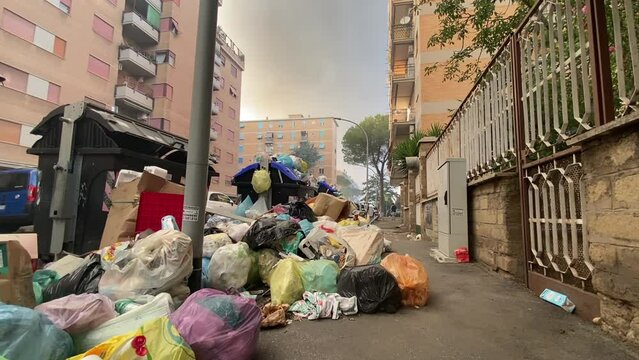 Lack of street cleaning in Rome, dirty garbage containers overfilled with trash packs, stinking garbage occupying street sidewalk, problem of trash in Rome