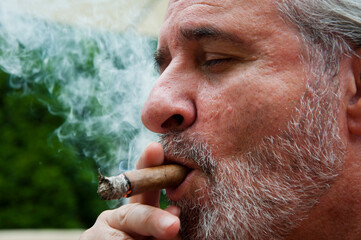 charismatic man smoking cigar. old man with cigar. man smoke cuban cigar. copy space