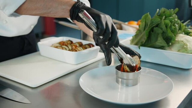 The chef serves ratatouille on a plate. Exquisite dish in an expensive restaurant.