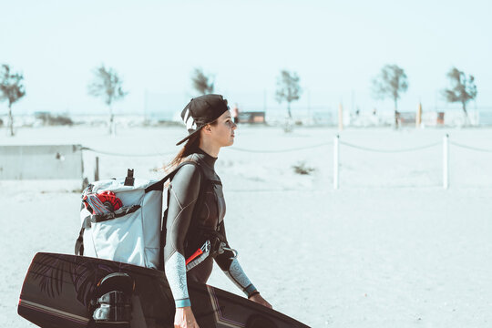 Beautiful girl focused and ready, comes to the beach with kitesurfing equipment - Sporty woman concept and hard sport