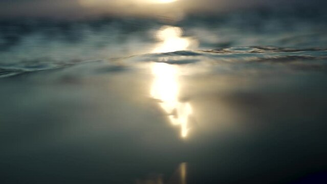 Sunlight reflects agaisn't the ocean, waves bob up and down. peaceful.