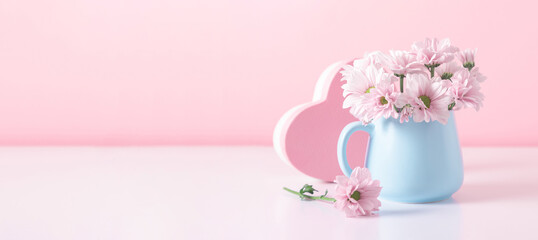 Pink flowers in blue cup against  pink wall. Valentine's Day, Happy Woman's Day, Mother's Day, Birthday, Wedding