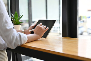 A woman freelancer relaxes sitting in the coffee shop and using tablet