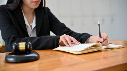 Fototapeta na wymiar Professional Asian female lawyer working at her office desk, writing a notice or Resignation letter