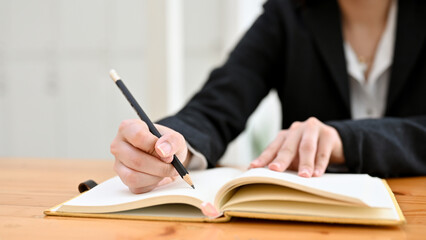 Cropped, Businesswoman or lawyer at her office desk, writing something on notebook.