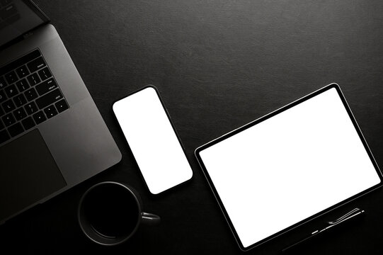 Stylish black office desk workspace top view, with smartphone and tablet mockup