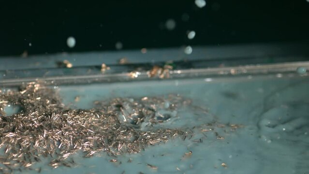 Super slow motion di gocce d'acqua su schegge di ferro