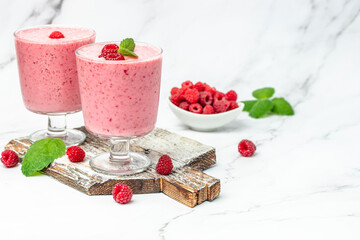 Yogurt smoothie with raspberries in glass on white marble table. Natural detox. Long banner format