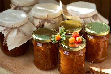 on a wooden and fabric background there are beautiful glass jars with orange sweet jam from orange...